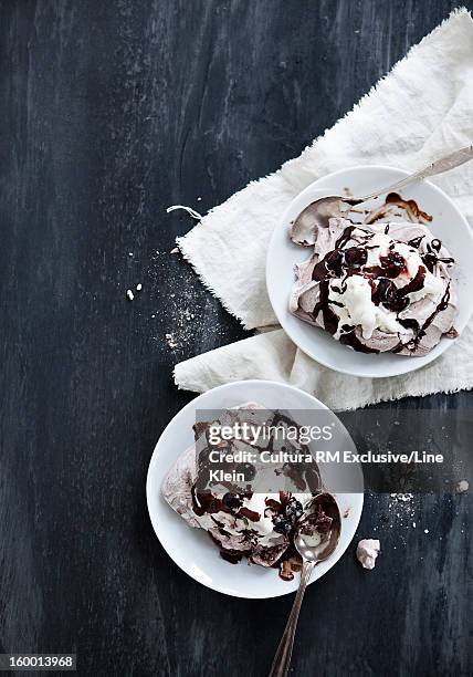 plates of meringue and chocolate - schlagsahne stock-fotos und bilder