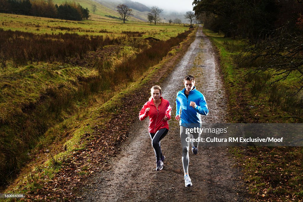 Couple running on dirt road