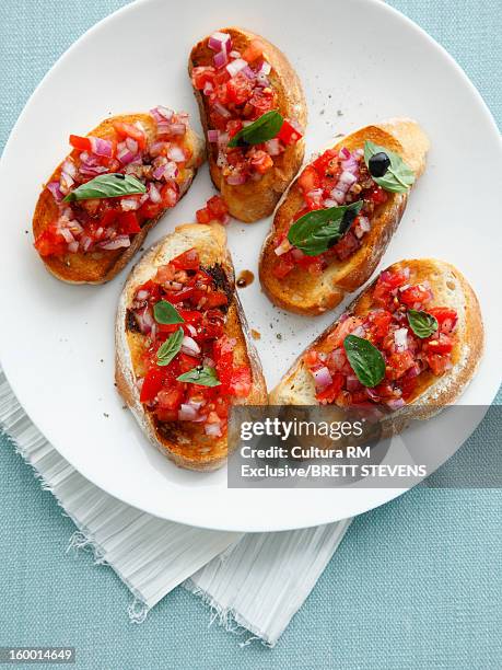 plate of tomato bruschetta - bruschetta stock-fotos und bilder