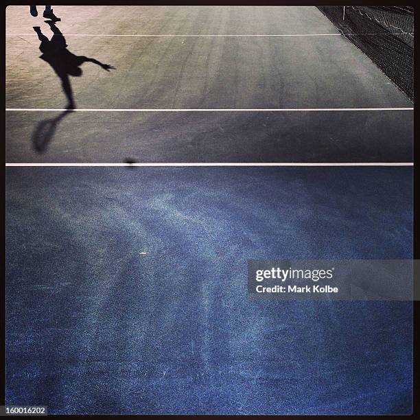 The shadow of Guillermo Garcia-Lopez of Spain is seen as he serves in his first round match against Rajeev Ram of the United States of America during...