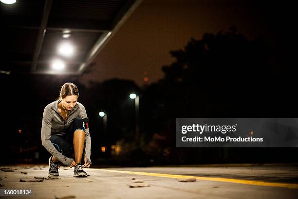 woman running at nighttime - tiersport stock pictures, royalty-free photos & images