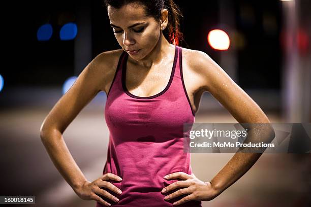 woman running at nighttime - sweating stock-fotos und bilder