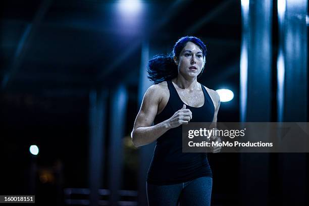 woman running at nighttime - joggerin stock-fotos und bilder
