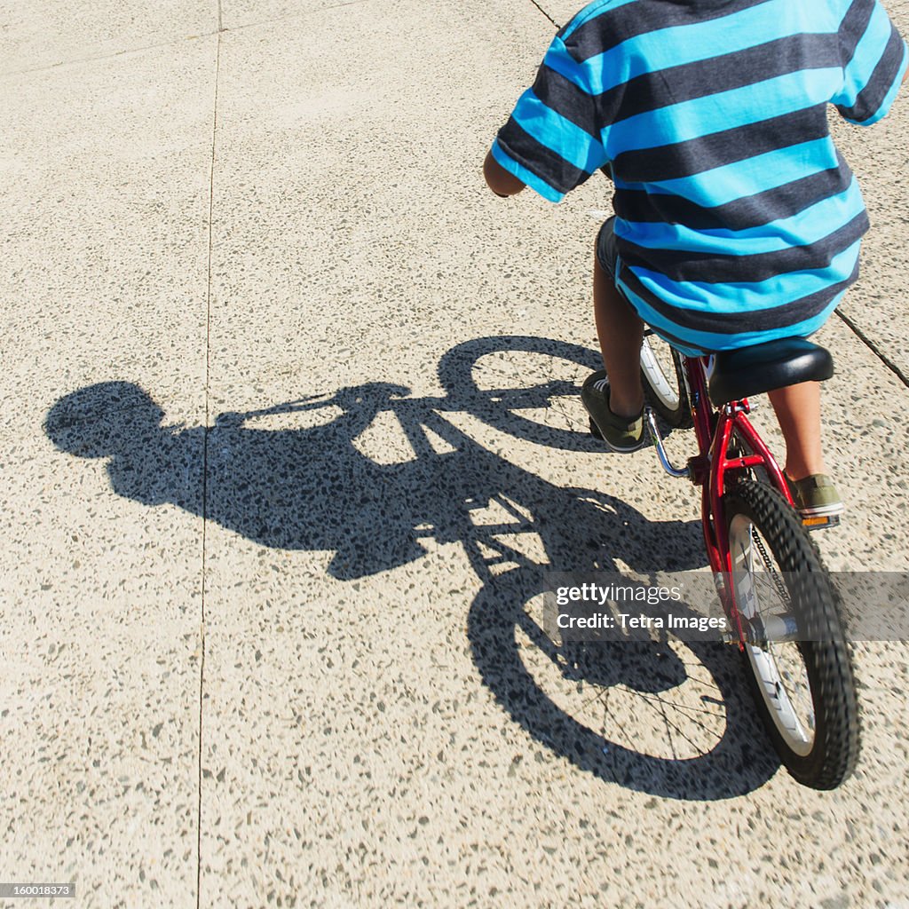 Low section of boy (6-7) riding bicycle