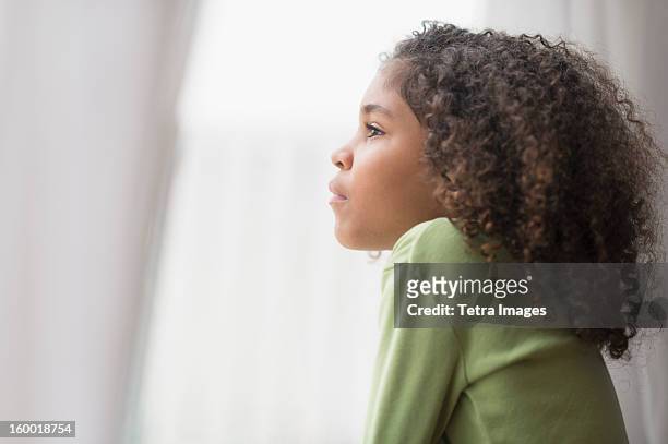 girl (6-7) looking through window - kid thinking stock pictures, royalty-free photos & images