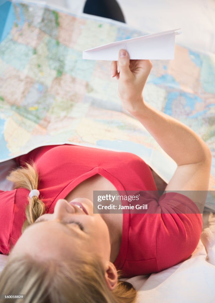 Young woman holding paper plane