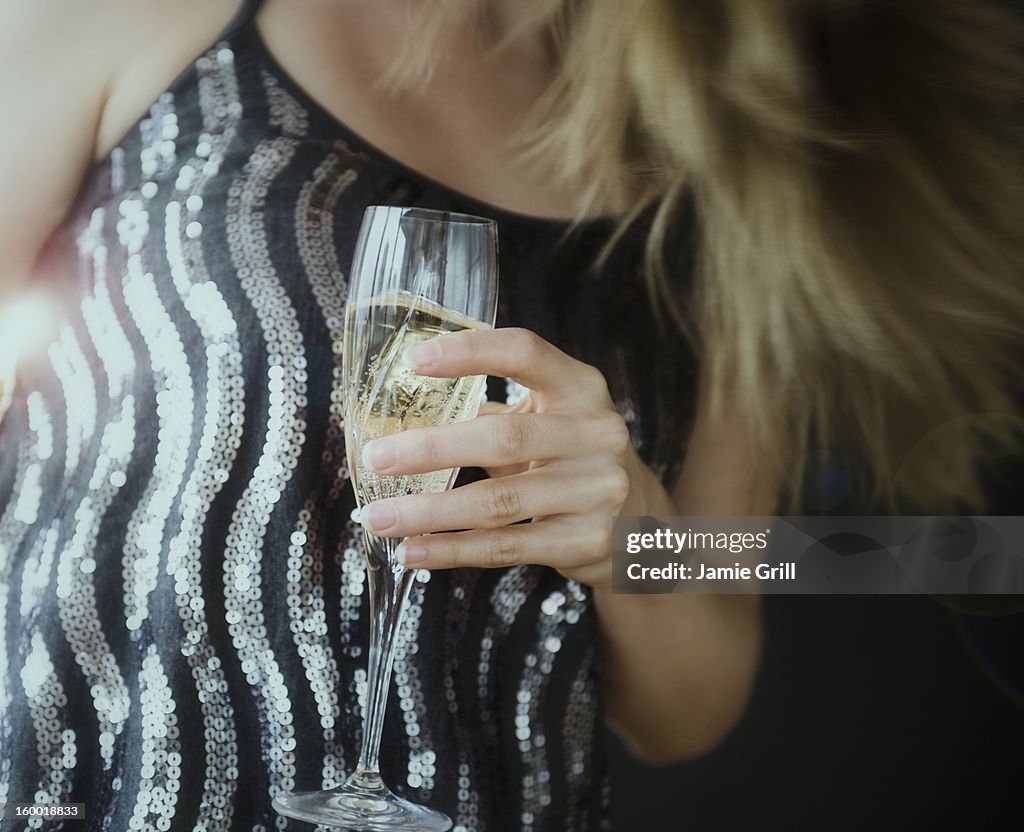 Young woman making toast with champagne