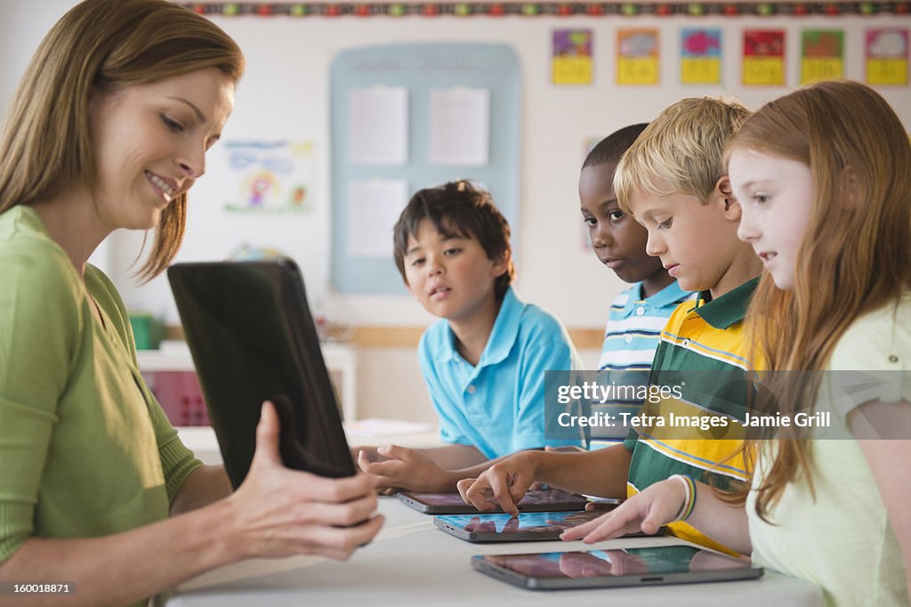 School children (8-9) with female teacher working with computers