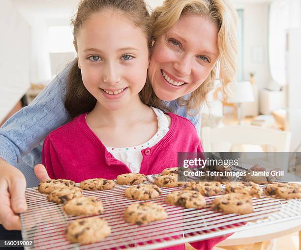 mother and daughter (8-9 years) baking cookies - 40 44 years woman caucasian stockfoto's en -beelden