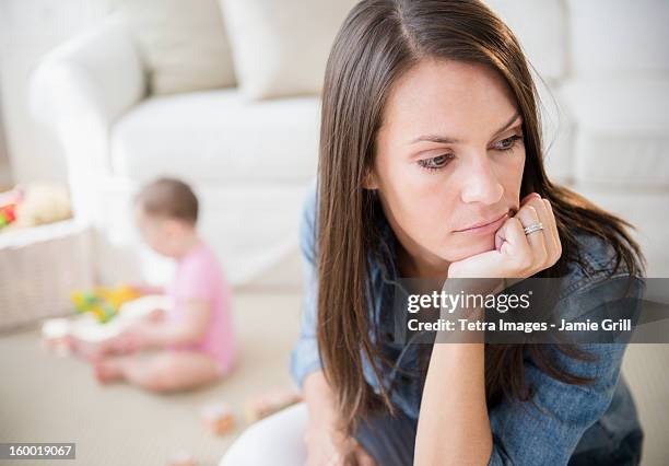 mother with daughter (6-11 months) in living room - depressed mother stockfoto's en -beelden