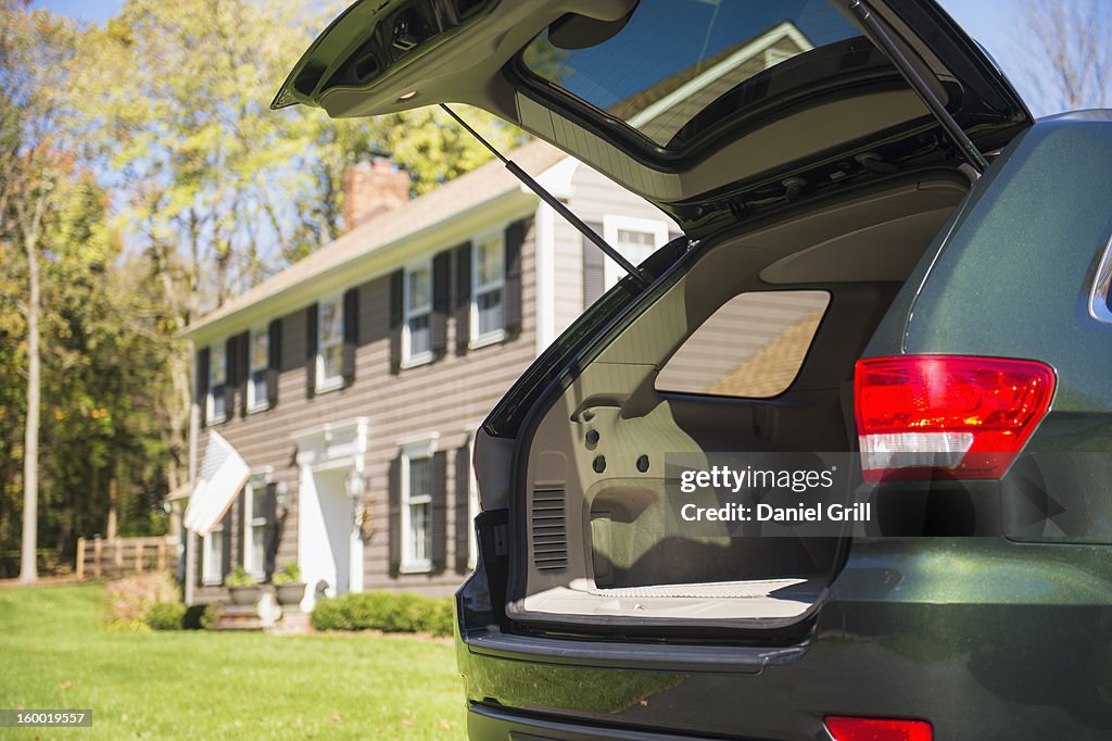 USA, New Jersey, Mendham, Open car trunk in front of house