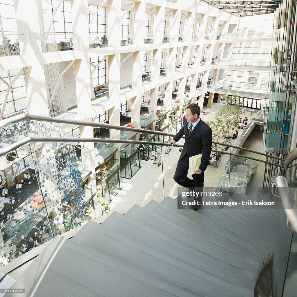 USA, Utah, Salt Lake City, Man walking up stairs in office