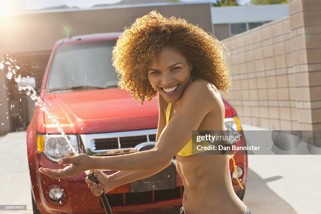 Mid adult woman washing car