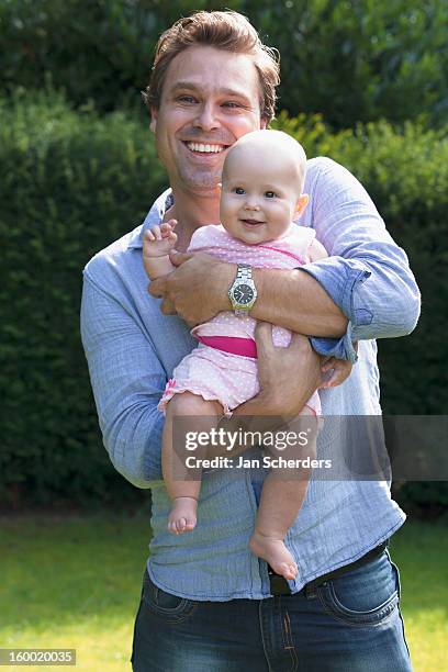 netherlands, mijnsheerenland, father with baby daughter (6-11 months) in park - mijnsheerenland stock pictures, royalty-free photos & images