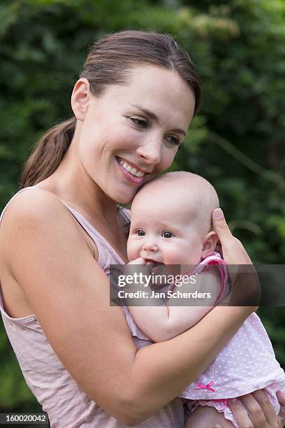 netherlands, mijnsheerenland, mother holding baby daughter (6-11 months) - mijnsheerenland stock pictures, royalty-free photos & images