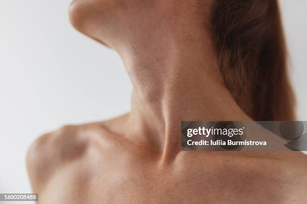 photo capturing alluring elegance of collarbone, neck and shoulders of gymnastic lady standing in white clean studio with soft lighting. - neck stock pictures, royalty-free photos & images