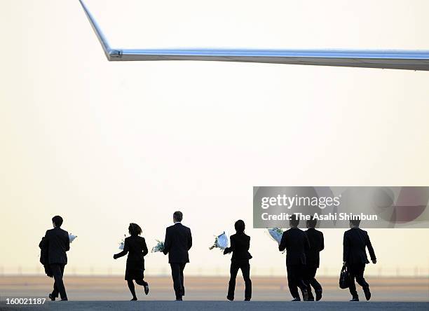 Staffs holding flower bunches walk toward a Japanese government aircraft at Tokyo International Airport on January 25, 2013 in Tokyo, Japan. A...