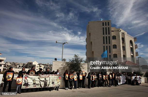 Palestinian protesters hold placards during a demonstration in support with Palestinian prisoners held in Israeli jails, some of whom are observing a...