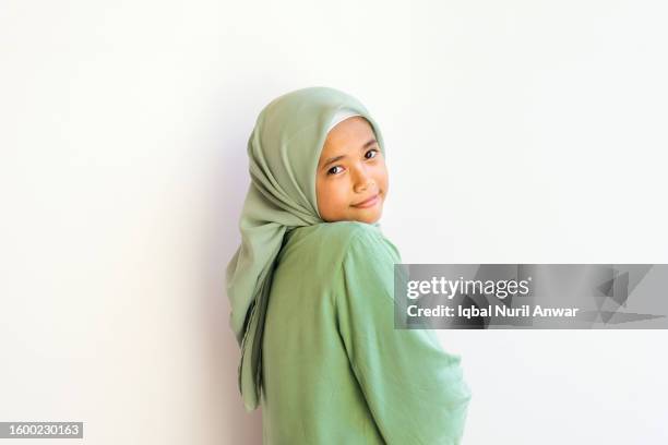 asian muslim girl smiling, posing charmingly looking at the camera with a white background - veil isolated stock pictures, royalty-free photos & images