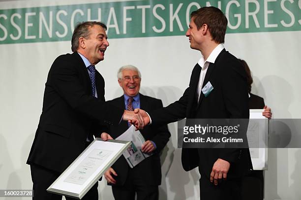 President Wolfgang Niersbach hands over the certificate to DFB Science Award winner Georg Froese during the DFB Science Congress 2013 at the...