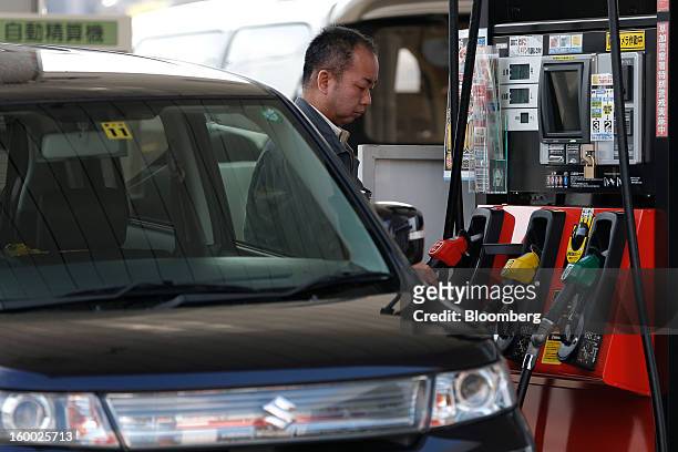 Customer reaches for a fuel pump at a self gas station in Soka City, Saitama Prefecture, Japan, on Friday, Jan. 25, 2013. Japan's consumer prices...