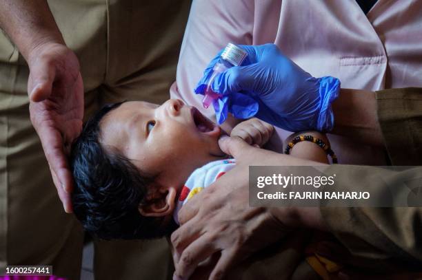 Child receives an oral vaccination against rotavirus, a common cause of diarrhea among Indonesian children, at a health center in Tangerang on August...