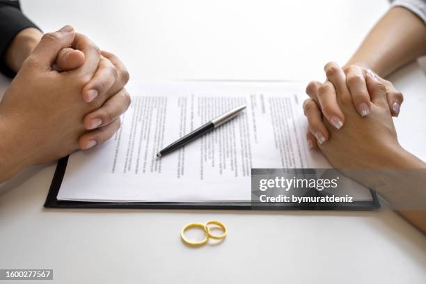 divorce agreement and wedding rings - alimony imagens e fotografias de stock