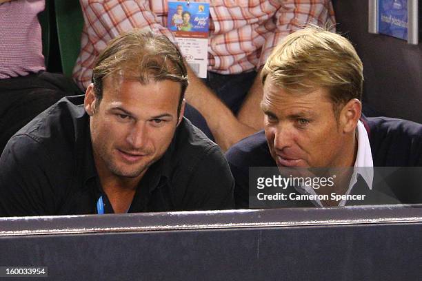 Shane Warne and AFL player Aaron Hamill watch Andy Murray of Great Britain and Roger Federer of Switzerland in their semifinal match during day...