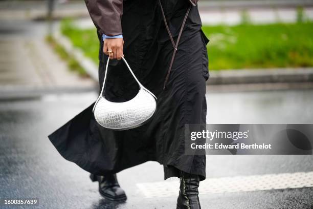 Guest wears a blue and white small striped print pattern shirt, a dark brown matte leather high neck puffy bomber coat, black large pants, a white...