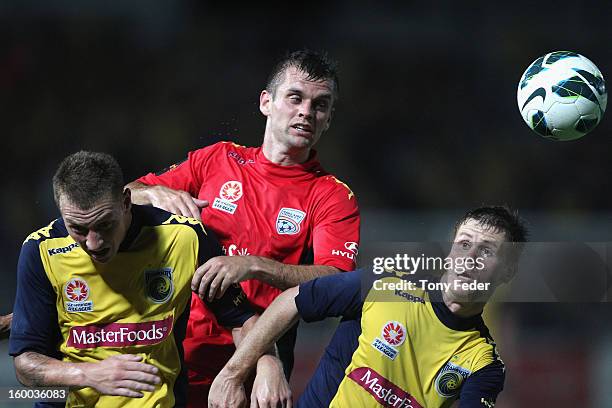 Cameron Watson of Adelaide heads the ball between Daniel McBreen and Michael McGlinchey of the Mariners during the round 18 A-League match between...