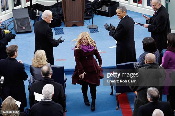 President Barack Obama and U.S. Vice President Joe Biden applaud after singer Kelly Clarkson finished her performance of 'My Country, 'Tis of Thee'...