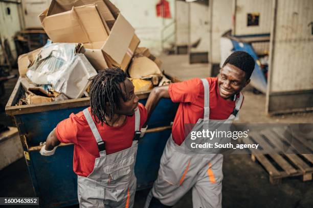 two workers in recycling centre moving big dumpster with paper - absence stock pictures, royalty-free photos & images