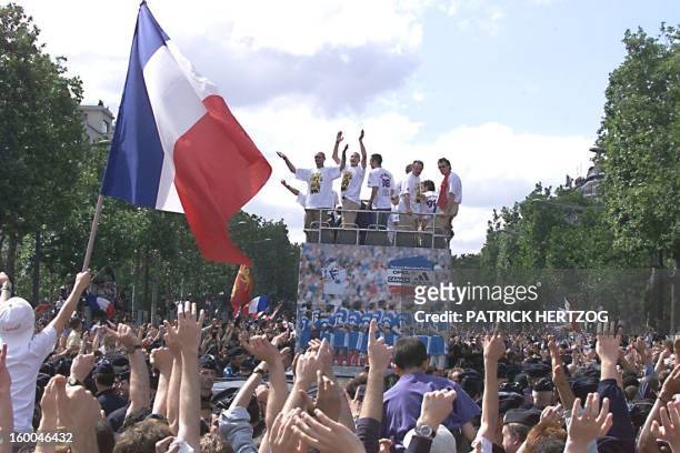 Players of the victorious French national soccer team wave to supporters during a parade on Champs Elysees avenue in Paris where hundreds of...