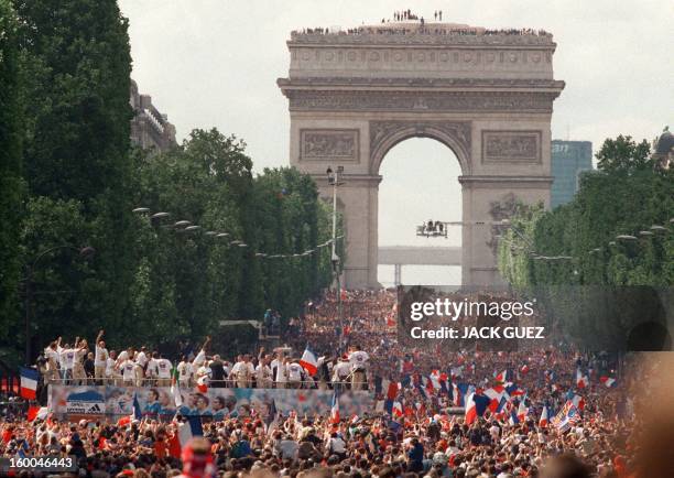 Players of the victorious French national soccer team wave to supporters during a parade on Champs Elysees avenue in Paris where hundreds of...