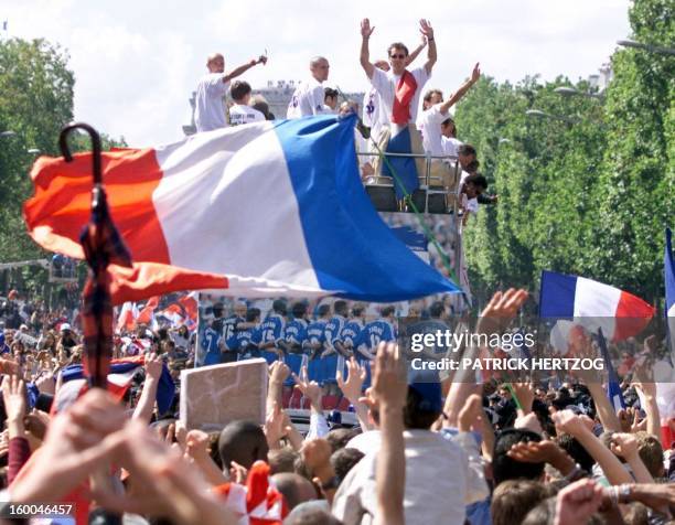 Players of the victorious French national soccer wave to supporters during a parade on Champs Elysees avenue in Paris, where hundreds of thousands of...