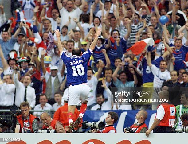 French Zinedine Zidane jumps over the barrier as he celebrates after scoring the first goal for his team 12 July outside the Stade de France in...