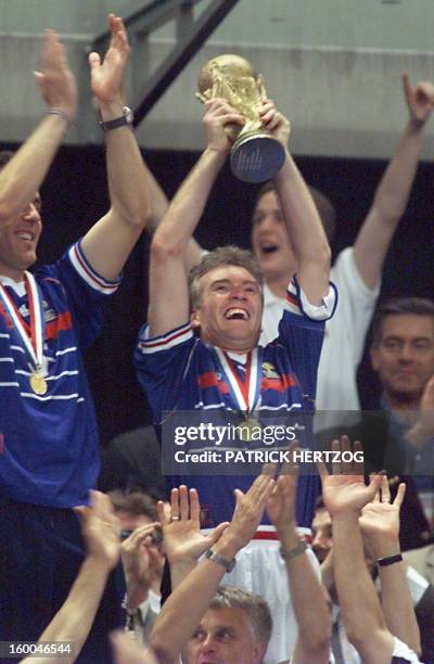 French Didier Deschamps waves the FIFA trophy 12 July at the Stade de France in Saint-Denis, near Paris, after winning the 1998 Soccer World Cup...