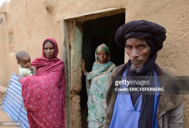 Ali Ag Noh poses on January 25, 2013 with his wife Zahra , his daughter and his son Aboubacrim in front of his house in the village of Seribala, 20...