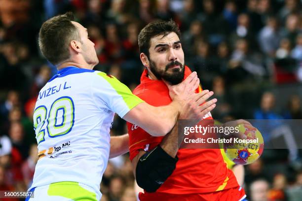 Luka Zvizej of Slovenia defends against Jorge Maqueda of Spain during the Men's Handball World Championship 2013 semi final match between Spain and...
