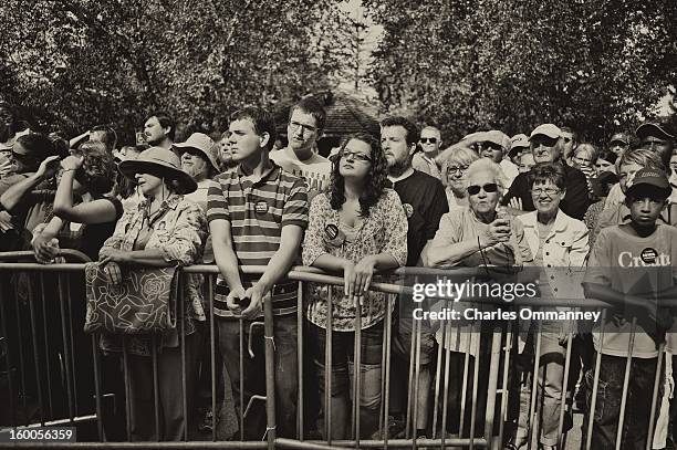 Spectators look on as US President Barack Obama delivers remarks during a campaign event at Herman Park in Boone, Iowa, on August 13, 2012. Obama...