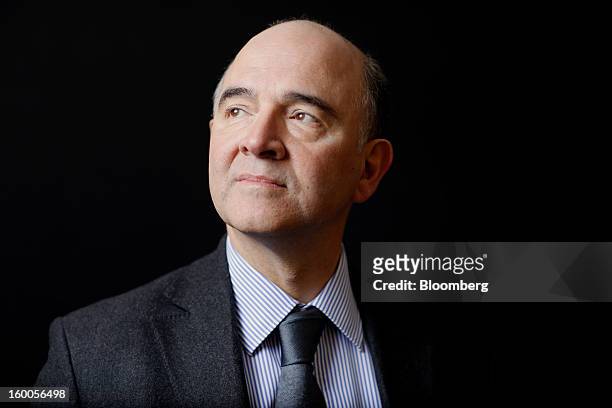 Pierre Moscovici, France's finance minister, poses for a photograph following a Bloomberg Television interview on day three of the World Economic...