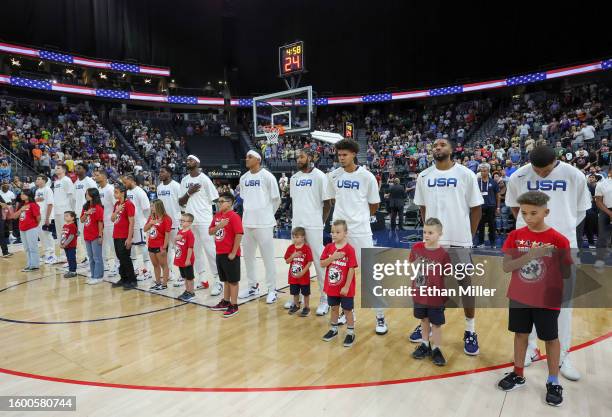 Children from the Tragedy Assistance Program for Survivors stand on the court as the United States national anthem is performed with Austin Reaves,...