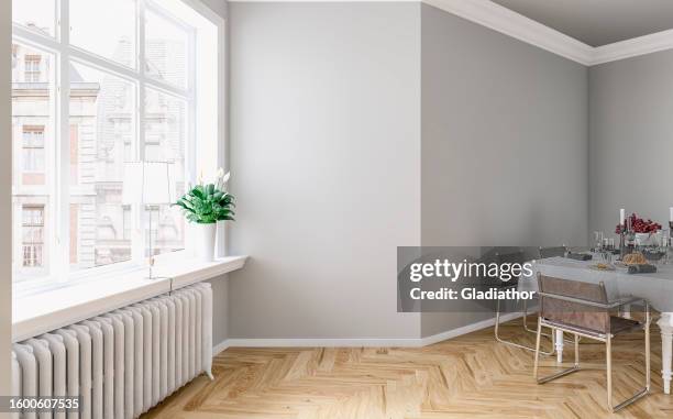 side view of an empty classic elegant interior - a modern, but classic dining room with a gray and white wall background, full dining table, and french-style windows with a city view - estilo clássico imagens e fotografias de stock