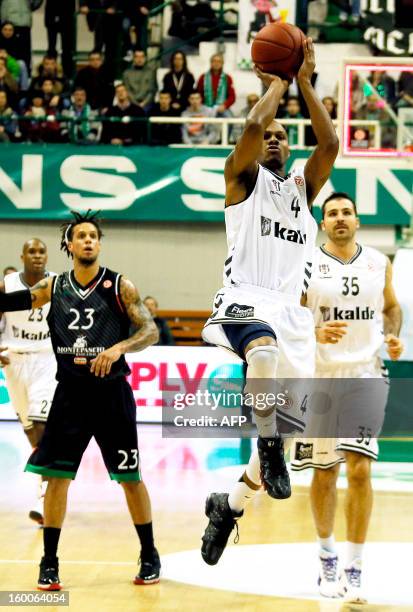 Besiktas' Daniel Ewing shoots to the basket next to Montepaschi's Daniel Hackett and Besiktas' Cemal Nalga during the Euroleague basketball Top 16...