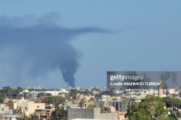 Smoke billows amid clashes between armed groups affiliated with Libya's Tripoli-based Government of National Unity in the Libyan capital on August...