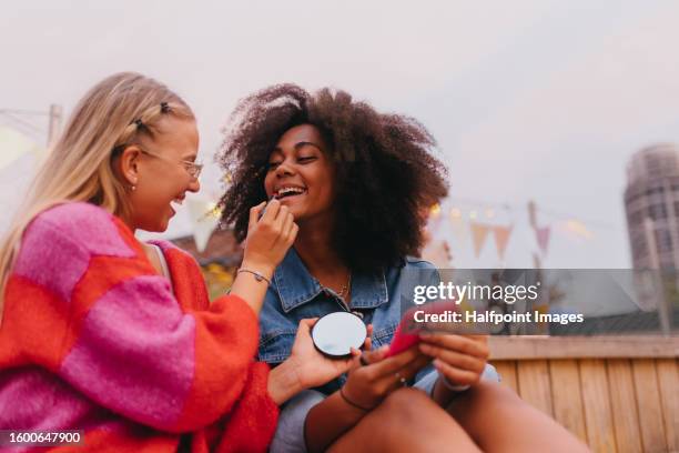 young stylish girl zoomers doing make-up outdoors. - friends women makeup ストックフォトと画像