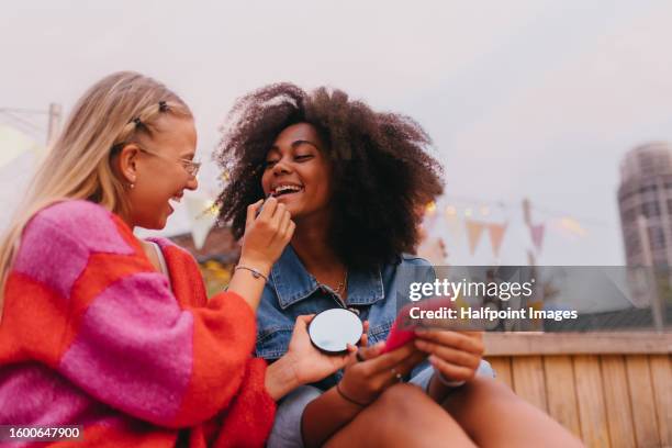 young stylish girl zoomers doing make-up outdoors. - friends women makeup stockfoto's en -beelden