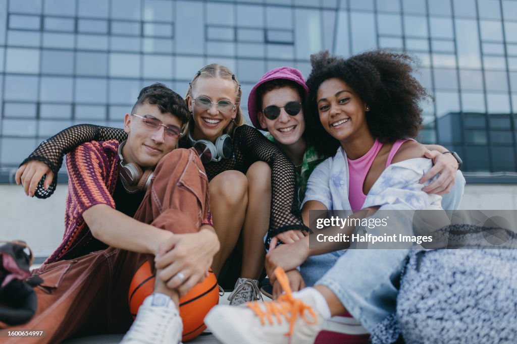Diverse group of generation z friends hanging out together outdoors in the city.