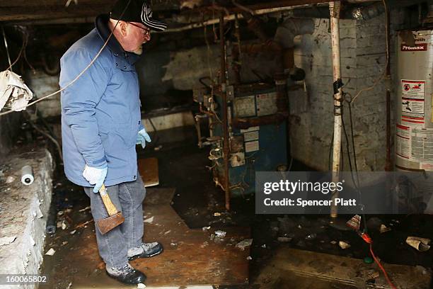 Mike Burke looks at his flooded and frozen basement in the Rockaways following Hurricane Sandy on January 25, 2013 in New York City. Burke has no...