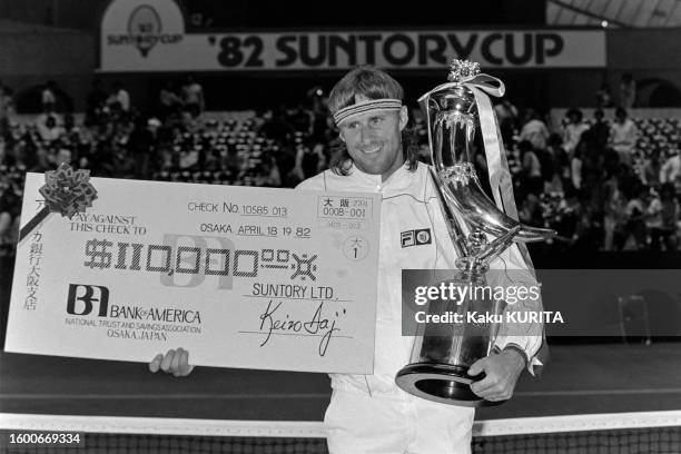 Björn Borg posant avec son trophée et son chèque après sa victoire à la Suntory Cup, le 18 avril 1982, à Tokyo